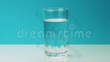 一片泡腾的黄色止痛片<strong>落入</strong>玻璃杯中，将慢镜头的阿司匹林溶解在水中
