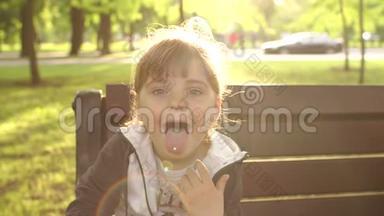 坐在公园长凳上露舌头的小女孩