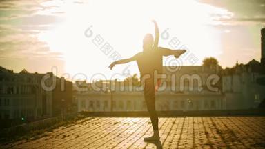 年轻优雅的女芭蕾舞演员在屋顶上训练她的舞蹈-日落