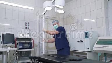 院内医生调整手术台.. 外科医生为手术准备一张桌子和<strong>医疗设备</strong>。