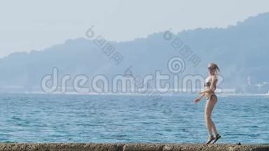 海湾中岛屿的景色。 远程摄影。 在防波堤上的女人在雾中<strong>看海</strong>岸，4K，慢慢地