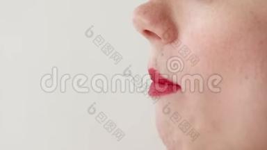 嘴唇红的女人吃草莓。 口特写.. 侧视。
