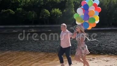 一对快乐的年轻夫妇带着一大堆<strong>气球</strong>跑步的慢动作<strong>视频</strong>