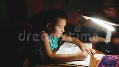 小女孩晚上做家庭<strong>作业</strong>读一本书和作家。 晚上做家庭<strong>作业</strong>女孩课从