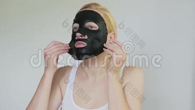 女，40岁，脸上戴着一个恢复青春活力的黑色组织面膜