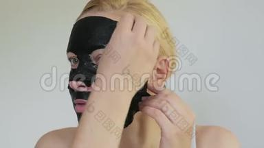 女，40岁，脸上戴着一个恢复<strong>青春活力</strong>的黑色组织面膜