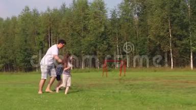 爸爸、儿子和女儿夏天在绿茵场上<strong>踢</strong>足球，<strong>踢</strong>足球