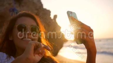 美丽的年轻混合种族女孩拍摄自拍照片，同时放松在海滩上的吊床惊人的日落。 高清高清