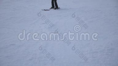 一双面目全非的女滑雪者在山上的雪坡上降下来。 在滑雪场滑下山的年轻女孩