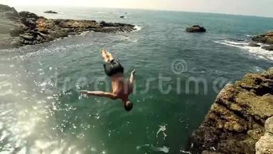 男运动员从悬崖跳入水中。