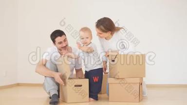 一家人带着男孩在新家收拾搬运纸板箱