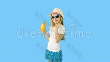 年轻的白种人女孩走路喝橙汁。 拇指向上的手势显示。