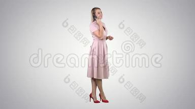穿粉色裙子的漂亮女孩在电话里的渐变背景。