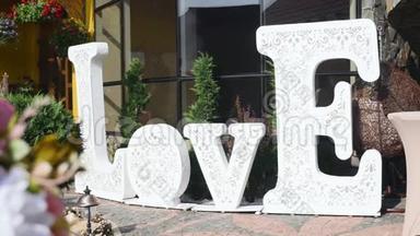 白色的大牌子，上面写着爱，站在宴会或婚宴附近