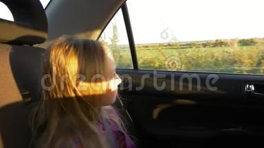 年轻的白人女孩看着窗户开车。 日落<strong>夏秋</strong>的傍晚.. 金色的日落。