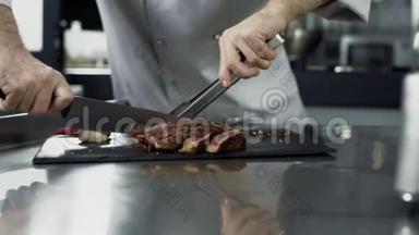 男厨师在厨房餐厅切牛排。 贴身厨师手切肉