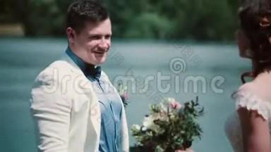 结婚纪念日。 美丽的一对夫妇在码头上拥抱，分享快乐的时刻。 结婚礼服，花束