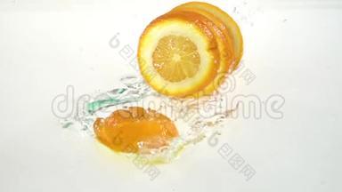 橙色掉进水中，薄片状地落在<strong>小叶</strong>上。 白色背景。 慢动作