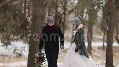 户外冬季拍摄，年轻的新婚夫妇在雪天松林中奔跑，玩得开心