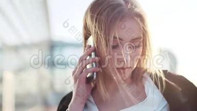 旋转的视角，一个迷人的年轻金发女人与自然化妆在她的电话。 成功的事业，现代