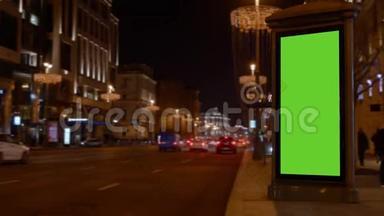 市街。 晚上好。 展示用大的绿色屏幕。 汽车来了。