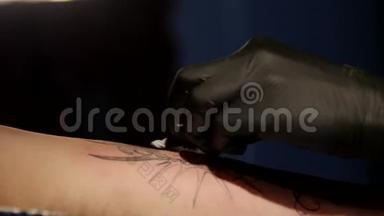 特写纹身艺术家演示了用油漆纹身的过程。 无菌手套。 纹身大师