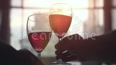 日落时，两个人在窗前喝着一杯红<strong>酒</strong>，欣赏着建筑城市的景色。 慢动作。 3840x2160