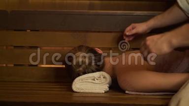 男人在桑拿、沐浴中做背部和<strong>颈部按摩</strong>美女。
