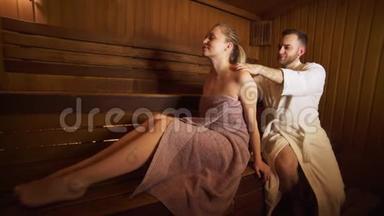 男人在桑拿、沐浴中做背部和<strong>颈部按摩</strong>美女。