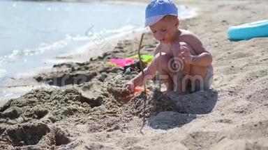 一个孩子在阳光明媚的热天在海滩上玩沙子和玩具。 娱乐和户外游戏