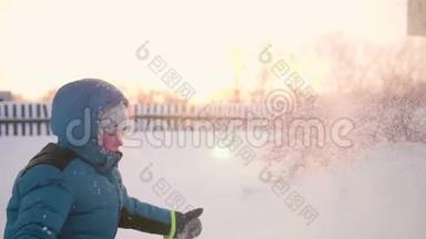 一个孩子在<strong>冬天户外</strong>玩耍，把雪扔到顶部。 积极的<strong>户外运动</strong>。 日落