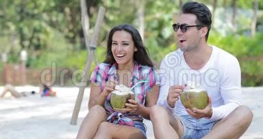 沙滩上的情侣、饮料、椰子、鸡尾酒、棕榈树下的谈话、欢乐的男人和女人的游客交流