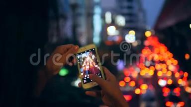 年轻的<strong>旅游</strong>女孩用手机拍摄<strong>曼谷</strong>城市的夜晚汽车交通。 <strong>泰国</strong>。 4K.