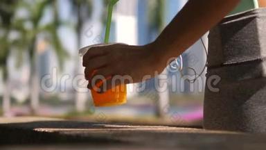 年轻的女运动员在城市公园完成锻炼和品尝新鲜橙汁杯。 4K，慢动作