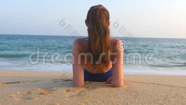 年轻女孩躺在<strong>海边</strong>和日光浴。 无法辨认的女人在暑假旅行期间在<strong>海边</strong>放松