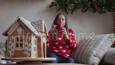 圣诞快乐，假日快乐。 年轻女子喝着温茶和圣诞饼干
