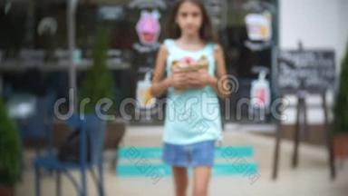 女孩带着羊角面包和一个甜甜圈离开糕点店，送给一群朋友。 模糊，特写。 4k，慢动作