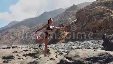 穿着紧身衣的年轻女子在令人惊叹的<strong>日</strong>出时在海面上的海滩上练习<strong>瑜伽</strong>。 <strong>健身</strong>、运动、<strong>瑜伽</strong>和健康