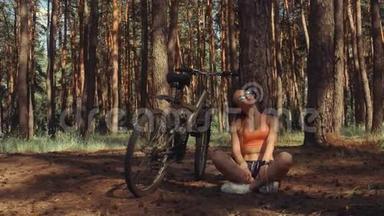 一位年轻的美女坐在树下，骑着自行车