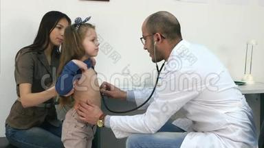 男儿科<strong>医生</strong>用听诊器听<strong>小女孩</strong>的胸部和背部