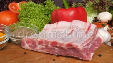 不同类型的肉放在生菜叶子蔬菜的背景上的木板上。 从侧面看