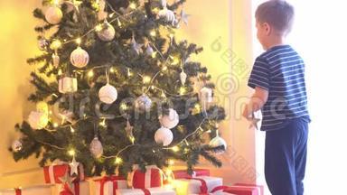 可爱的小男孩用球和灯装饰圣诞树。在家里准备<strong>过年</strong>的孩子。