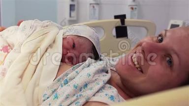 一个新生婴儿躺在医院里一位幸福的母亲的乳房上。 人生的第一分钟。