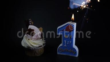 生日会盛宴庆祝理念.. 一个纸杯蛋糕和一支燃烧的蜡烛。 <strong>一周年</strong>纪念日。 一个球杆
