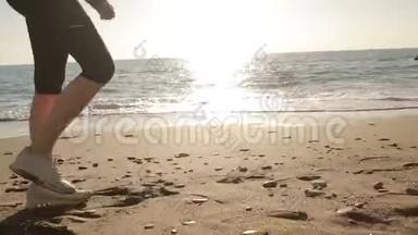 女人`穿着<strong>跑鞋</strong>的腿，沿着海滨、海洋奔跑。 在海边奔跑