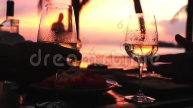 一对恋爱中的情侣在令人惊叹的日落时分用白葡萄酒碰杯。 高清，1920x1080。 慢动作