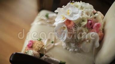 两束美丽的粉色和白色玫瑰和兰花的婚礼花束躺在古董古董椅上。