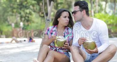 沙滩上的情侣、饮料、椰子、鸡尾酒、棕榈树下的谈话、欢乐的男人和女人的游客交流