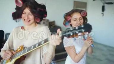 两个有趣的女孩用梳子唱歌，弹电吉他跳舞，在家唱歌，玩得开心