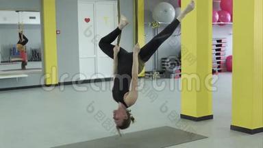瑜伽大师做一个倒立的姿势，挂在吊床上，用于空中瑜伽